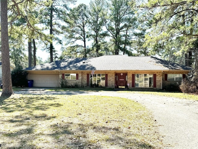 ranch-style home with brick siding, an attached garage, and a front yard