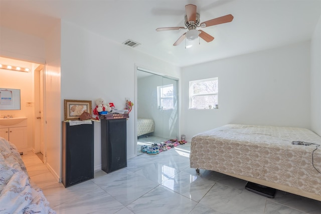 bedroom featuring marble finish floor, a closet, visible vents, a ceiling fan, and a sink