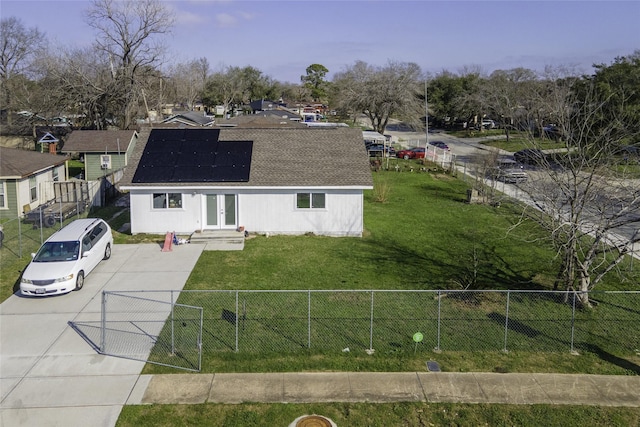 colonial inspired home featuring fence private yard, a front lawn, solar panels, and french doors