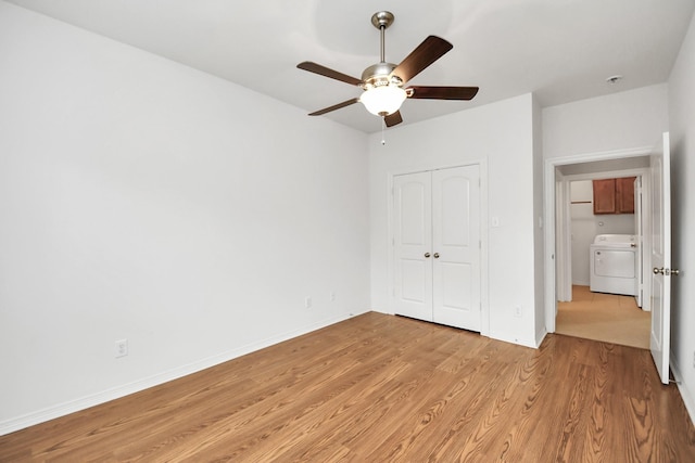 unfurnished bedroom with a ceiling fan, baseboards, a closet, light wood-type flooring, and washer / dryer