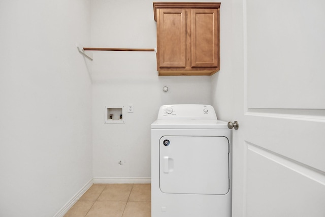 laundry area featuring washer / dryer, light tile patterned floors, baseboards, and cabinet space