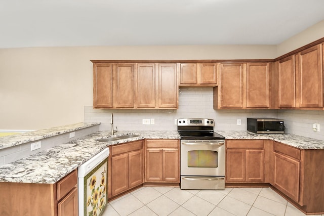 kitchen with stainless steel appliances, light tile patterned floors, a sink, and tasteful backsplash