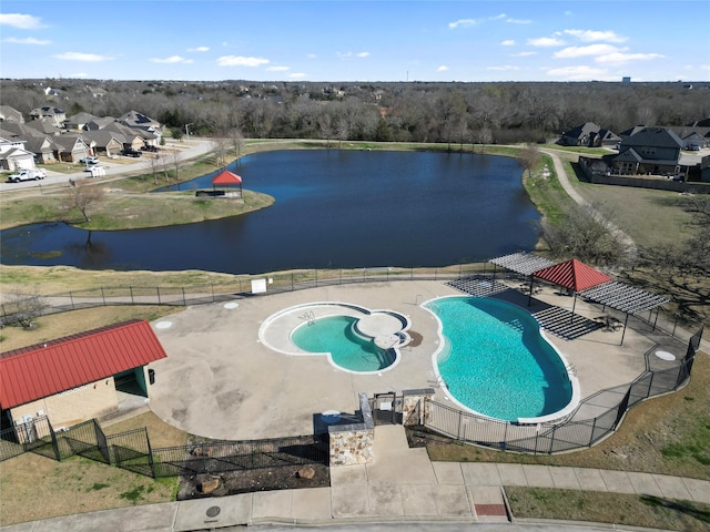 community pool with a water view and fence