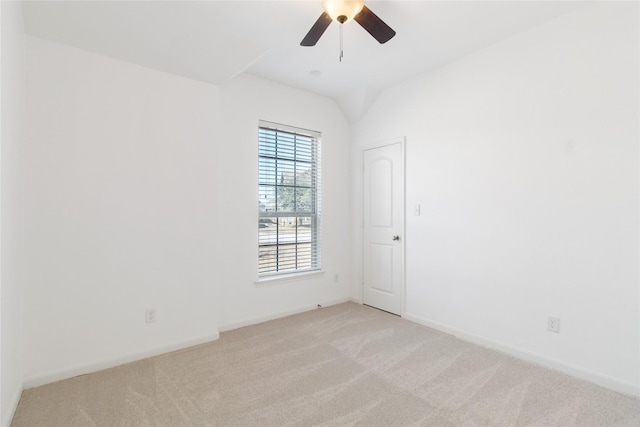 spare room featuring baseboards, ceiling fan, vaulted ceiling, and light colored carpet