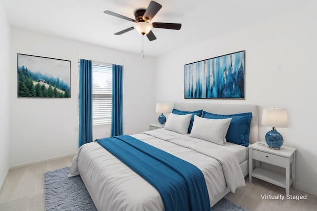 carpeted bedroom with ceiling fan and baseboards