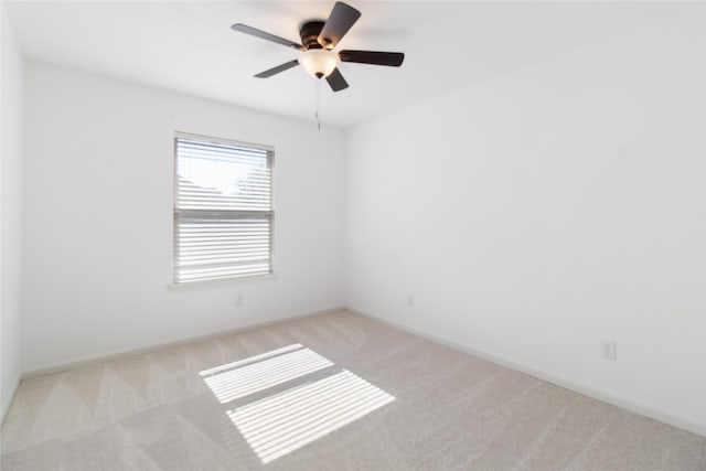 carpeted spare room with ceiling fan