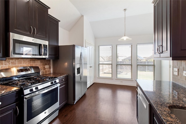 kitchen featuring stainless steel appliances, vaulted ceiling, dark brown cabinets, dark wood-style floors, and dark stone countertops