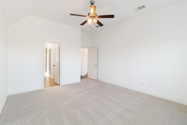 unfurnished bedroom with light colored carpet, visible vents, vaulted ceiling, and ceiling fan