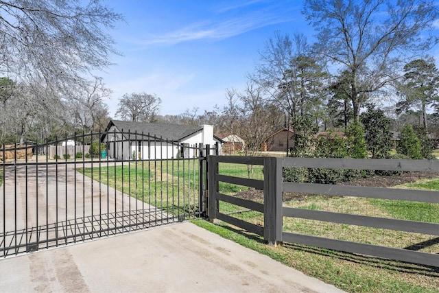 view of gate with fence and a yard