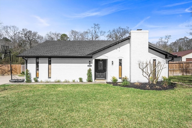 view of front of home featuring a front yard, brick siding, and fence