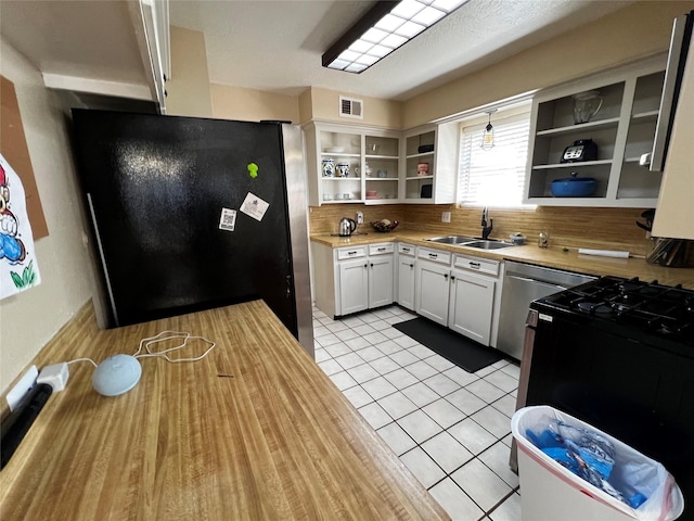 kitchen with light tile patterned floors, visible vents, appliances with stainless steel finishes, open shelves, and a sink