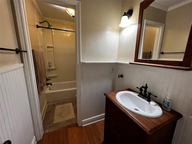 full bathroom with wood finished floors, bathing tub / shower combination, vanity, wainscoting, and crown molding