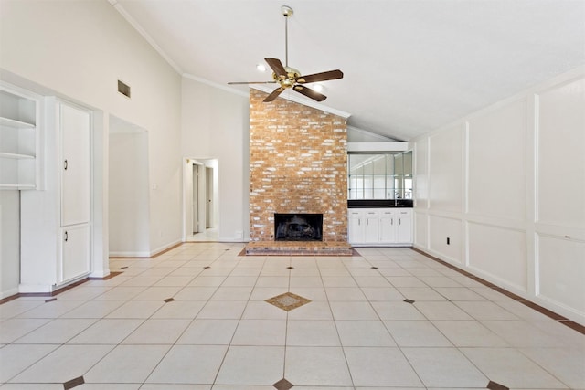 unfurnished living room with built in features, a fireplace, light tile patterned floors, a decorative wall, and ornamental molding