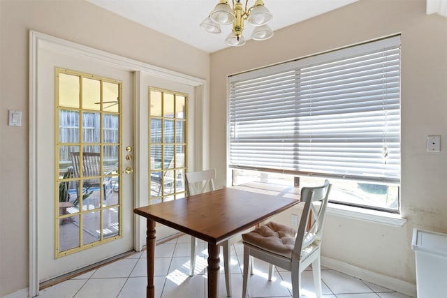 dining room featuring baseboards, light tile patterned flooring, and an inviting chandelier