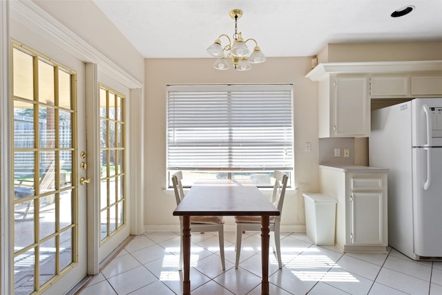 dining space featuring a wealth of natural light, an inviting chandelier, and light tile patterned floors