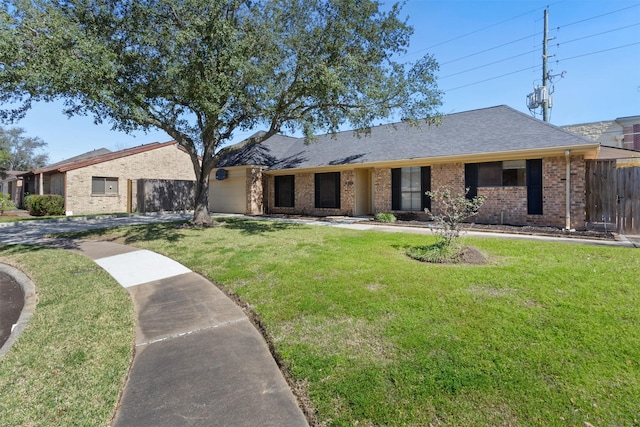 single story home featuring an attached garage, brick siding, fence, and a front yard