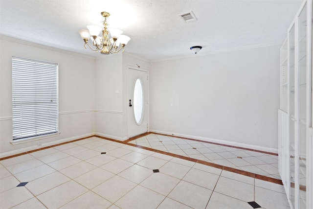 entrance foyer featuring a chandelier, visible vents, ornamental molding, and baseboards