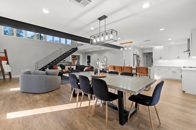 dining area with stairway, light wood-style flooring, visible vents, and recessed lighting