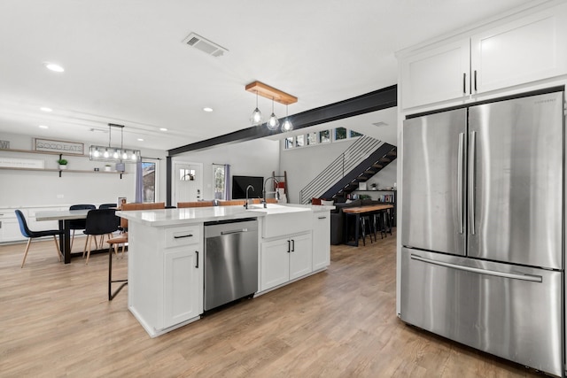 kitchen featuring a sink, visible vents, white cabinetry, light countertops, and appliances with stainless steel finishes