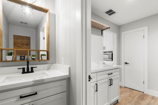 bathroom with wood finished floors, vanity, and visible vents