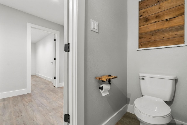 bathroom featuring toilet, baseboards, and wood finished floors