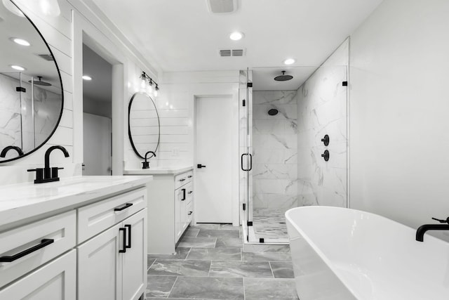 full bath with a marble finish shower, visible vents, marble finish floor, a freestanding tub, and a sink