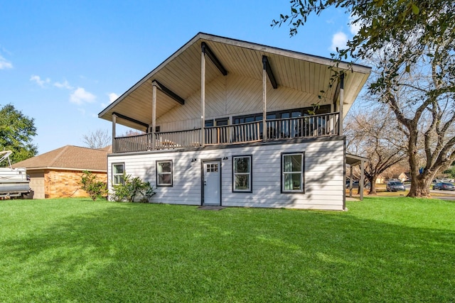 rear view of property with a yard and a balcony