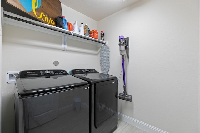 laundry room with laundry area, baseboards, and washer and dryer