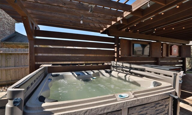 view of pool with a hot tub, fence, and a pergola