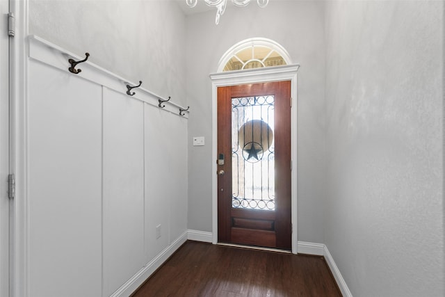 foyer with dark wood-style flooring and baseboards