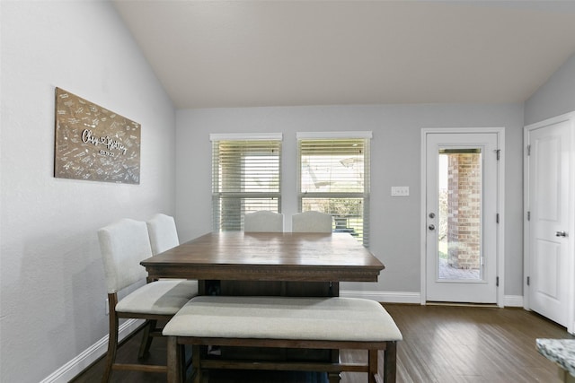 dining room featuring dark wood-style floors, baseboards, and vaulted ceiling