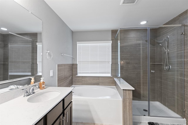 full bath featuring visible vents, a garden tub, a shower stall, and vanity