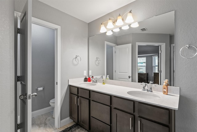 full bathroom with visible vents, a sink, toilet, and double vanity