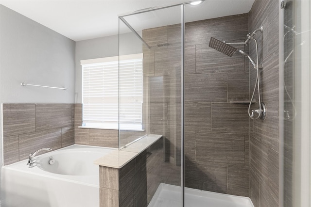 bathroom featuring a stall shower and a bath