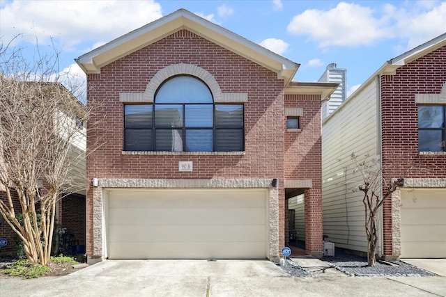 view of front of home featuring a garage, driveway, and brick siding