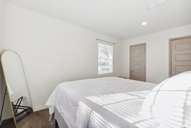 bedroom featuring wood finished floors, recessed lighting, and baseboards