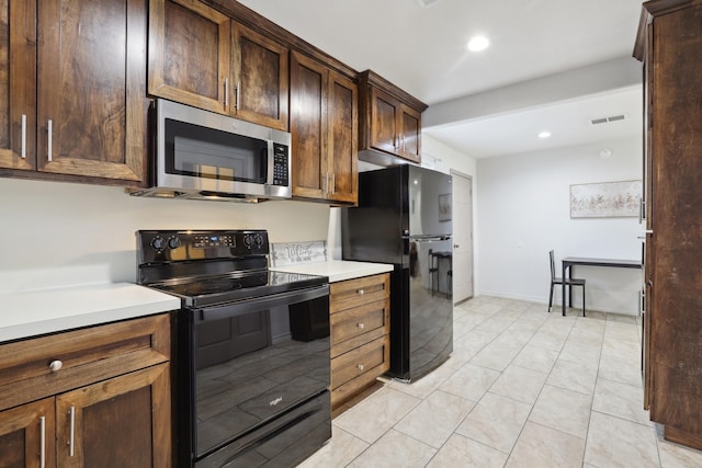 kitchen featuring visible vents, light tile patterned flooring, light countertops, black appliances, and recessed lighting