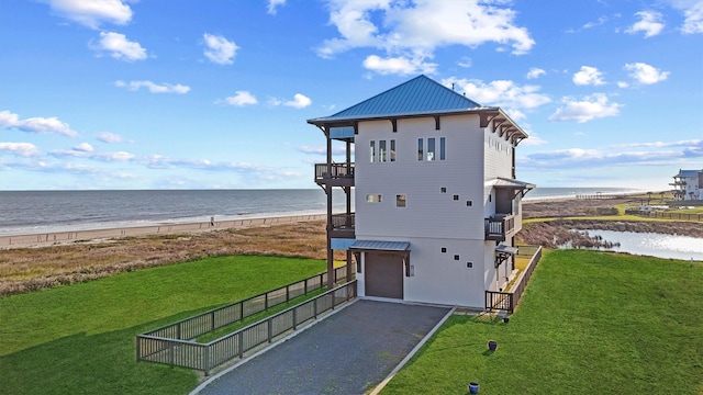 view of outbuilding featuring a water view, a view of the beach, and gravel driveway