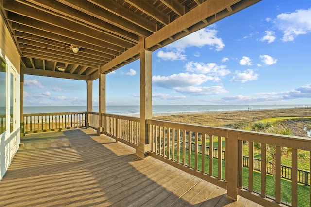 wooden deck featuring a view of the beach and a water view