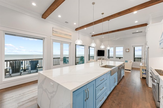 kitchen featuring dark wood-style floors, a spacious island, a sink, blue cabinetry, and beam ceiling