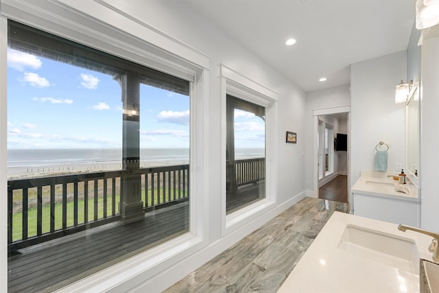 bathroom with recessed lighting, vanity, baseboards, and wood finished floors