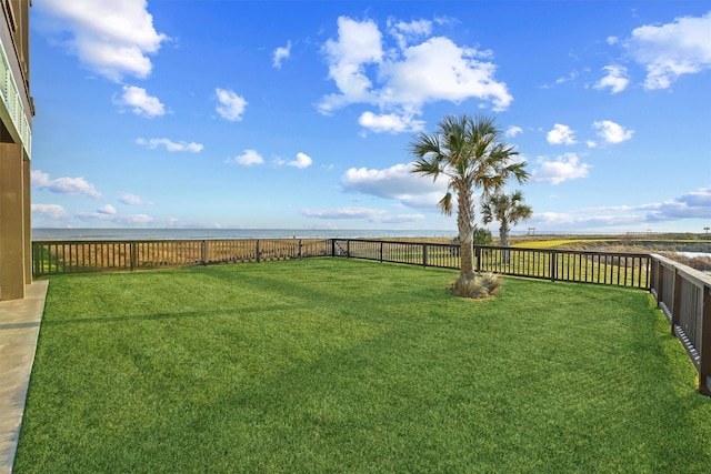 view of yard with a water view and fence