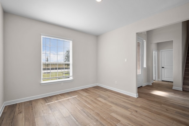 empty room with light wood finished floors and baseboards