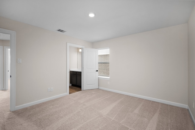 unfurnished bedroom with visible vents, baseboards, carpet flooring, and ensuite bathroom