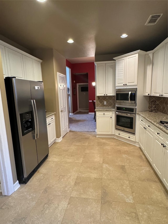 kitchen with tasteful backsplash, visible vents, stainless steel appliances, white cabinetry, and recessed lighting