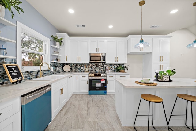 kitchen featuring appliances with stainless steel finishes, visible vents, a sink, and open shelves