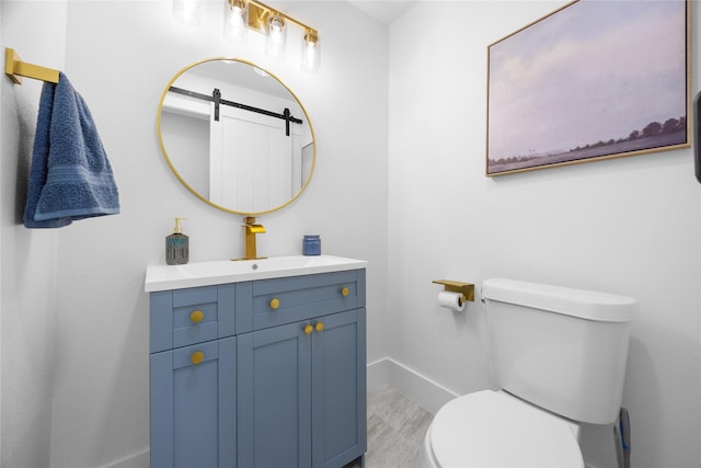 bathroom with vanity, toilet, and baseboards