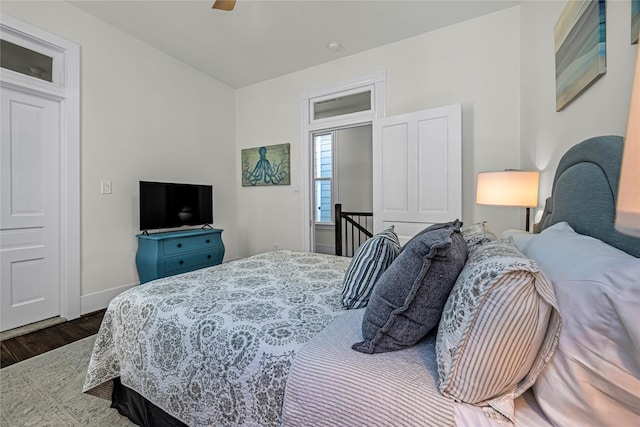 bedroom featuring ceiling fan, wood finished floors, and baseboards