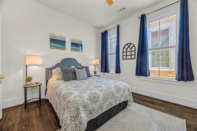 bedroom featuring wood finished floors, visible vents, and baseboards