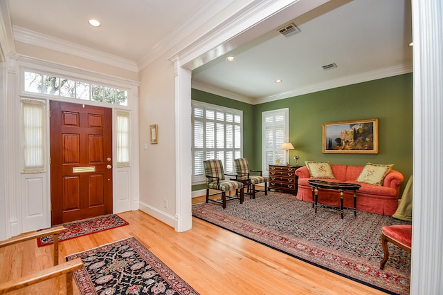 foyer featuring plenty of natural light, visible vents, and ornamental molding